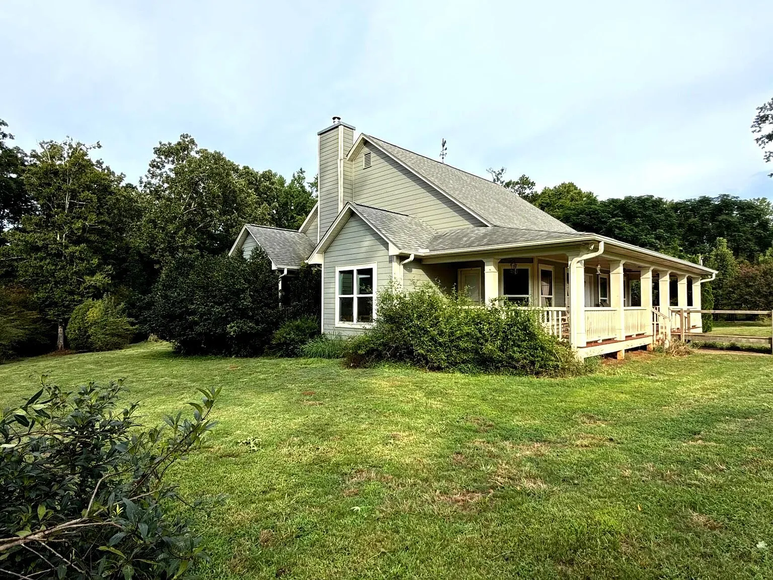 A Wraparound Porch With Grazing Cattle Next Door