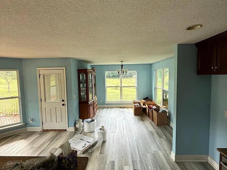 A Wraparound Porch With Grazing Cattle Next Door