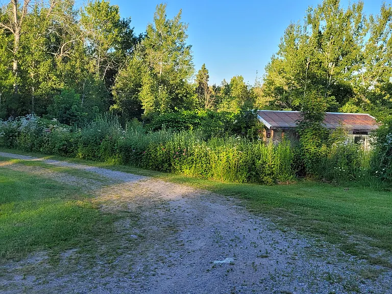 Three-Generation Stone Farmstead with Greenhouse, Barn, and Pond on 30 Acres Near Sault Sainte Marie